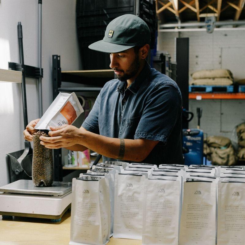 Coffee roaster from Corvus coffee bagging coffee in warehouse