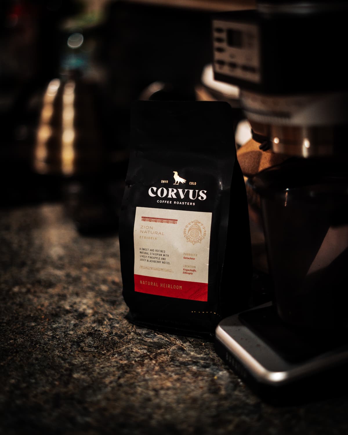 Bag of specialty coffee from Corvus Coffee next to grinder